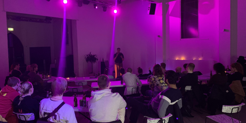 Billede fra arrangement med optrædende og tilhørere.