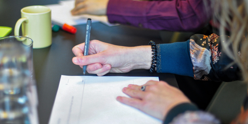 gruppe mennesker der sidder rundt om bord og skriver